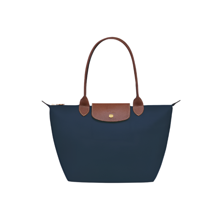 Navy blue handbag with brown leather handle and trim on a light gray background- navy blue purse