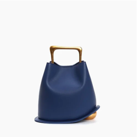 Navy blue Ayla handbag with a gold handle on a white background