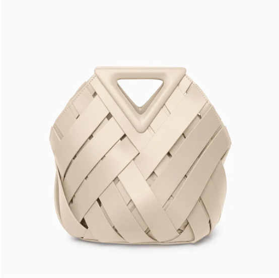 Beige veya handbag with a geometric handle on a white background