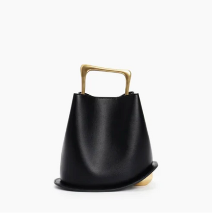 Black ayla handbag with a gold handle on a white background