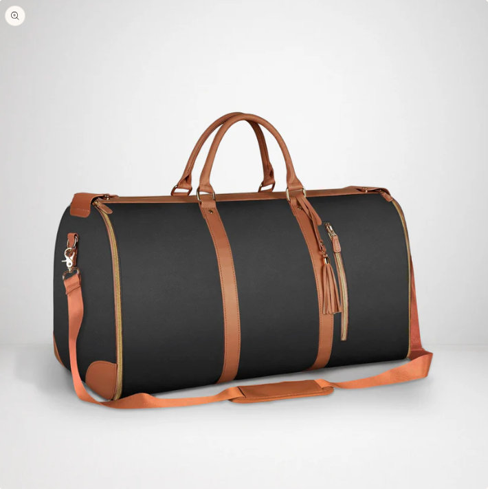 Black duffel bag with brown leather straps and handles on a light gray background