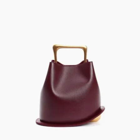 Burgundy ayla handbag with gold handle on a white background