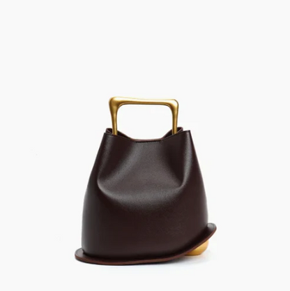 Chocolate ayla handbag with a gold handle on a white background