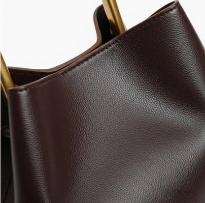 Close-up of a chocolate ayla handbag with gold accents