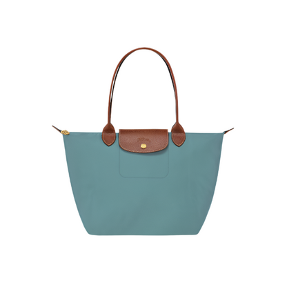 Teal handbag with brown leather handle and accents on a light gray background- teal purse