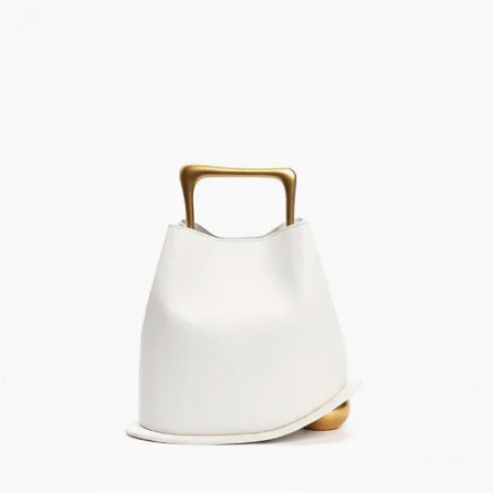 White ayla handbag with a gold handle on a white background