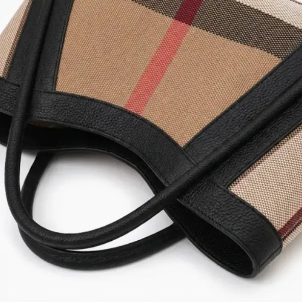 Close-up of luno handbag with checkered pattern and black handle on a white background