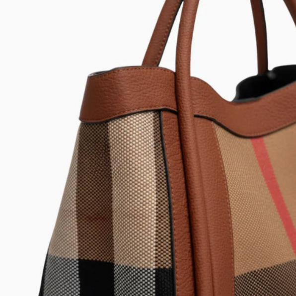 Close-up of brown and beige checkered handbag with mesh side panels.
